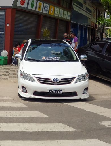 shot of a white Japanese compact Toyota Corolla 2000s. Front view. Expo Warnes 2021 classic car show. Copyspace