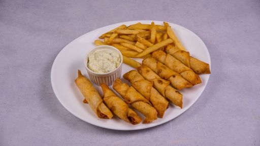 A closeup shot of french fries, sauce, and chips with meat on a white plate