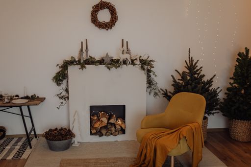 A yellow armchair with a blanket and holiday decor in Scandinavian style