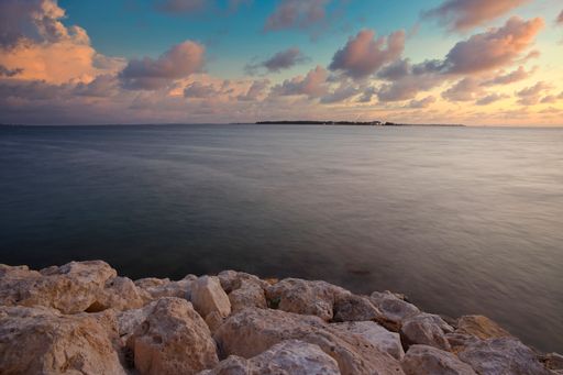 A beautiful view of a sea under the cloudy sunset sky