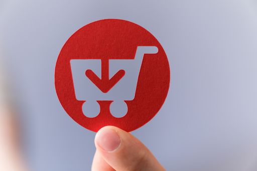 A red shopping cart sign with an arrow down-online downloading and purchasing
