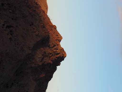 A vertical shot of a peak of a rocky hill.