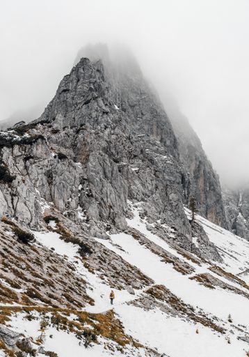A Caucasian female hiker on a snowy path on a slope of Mount Moistrocca in the Julian Alps, Slovenia