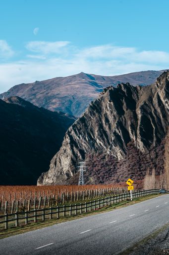 A vertical shot of a road constructed near the mountains