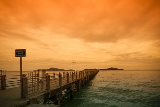A beautiful shot of a pier on a sea under the cloudy colorful skies in Rawai Beach, Phuket