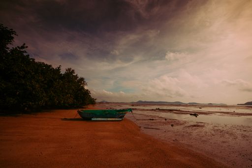 A beautiful shot of a boat near a sea under the cloudy skies in Ao Chalong, Phuket, Thailand
