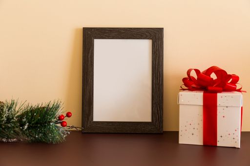 A blank wooden frame with decorative Christmas tree branch and present