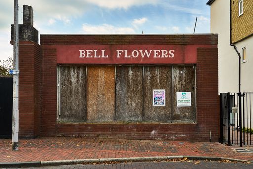 An empty and derelict shop with the writing "BELL FLOWERS" on it in the town of Sittingbourne, UK.