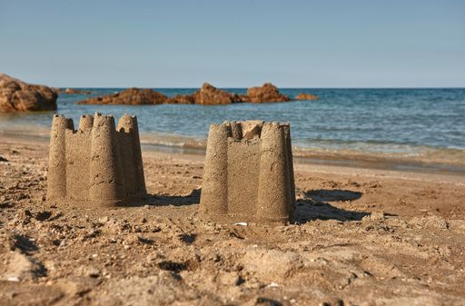 Pair of sand castles built on the golden sands of Cala Sa Figu beach in the south of Sardinia.