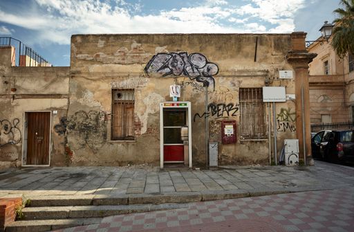 Small decaying building covered with graffiti taken in an alley in the city of Cagliari in Sardinia, Italy.