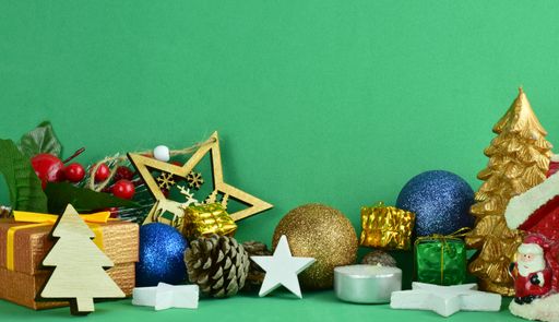 A colorful Christmas decoration and toys on a green background with copy space