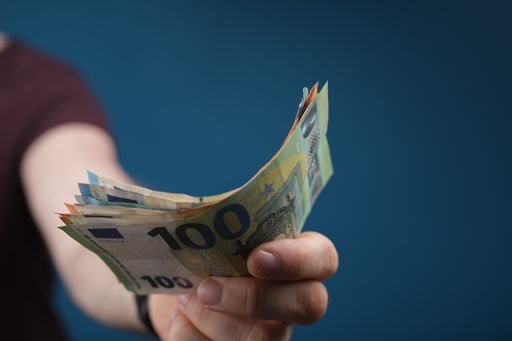 A closeup shot of a man's hand holding euro bills