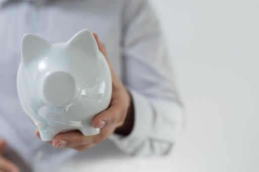 A man holding a white piggy bank with a white background