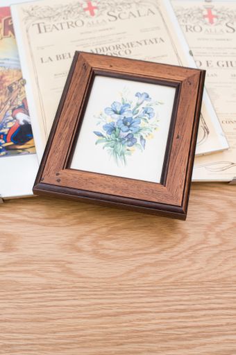 images and posters in glass clip frames on a wooden surface with copy space