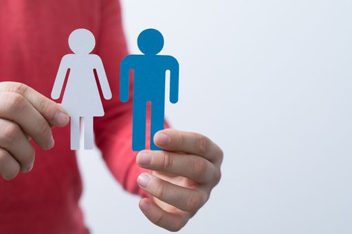 A man holding the paper cutouts of human figures