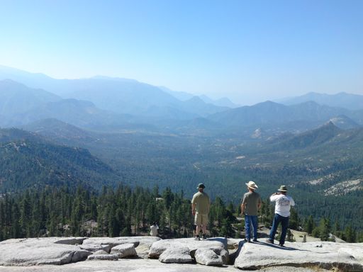 The people standing on the edge of the cliff enjoying the beautiful view of the highland.