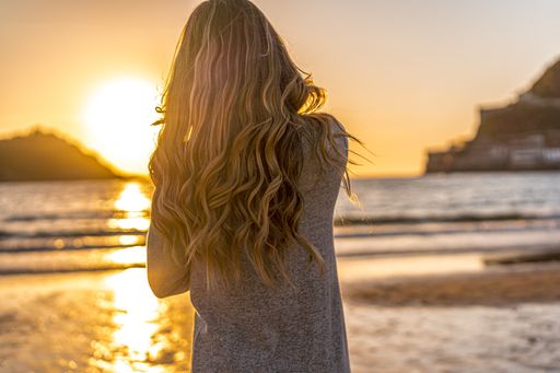 A beautiful young Colombian blonde on the beach at sunset in San Sebastian, Spain