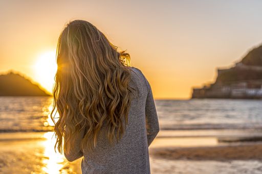 The beautiful blonde hair of a young Colombian female posing at the beach at sunset in San Sebastian, Spain