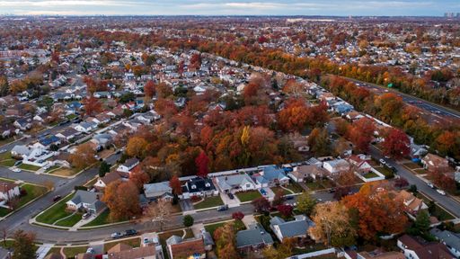 An aerial view over Long Island in New York at sunset during fall time and showing fall foliage