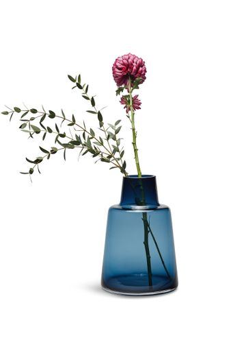 A vertical shot of dahlias in a blue glass vase under the lights isolated on a white background