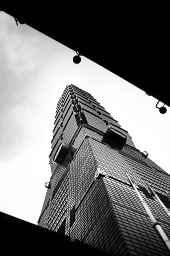 A vertical shot of the Taipei 101 Observatory from underneath in grayscale