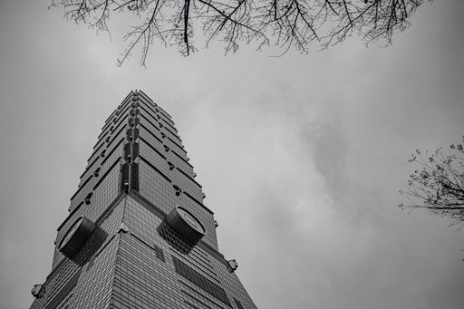 A low angle shot of the Taipei 101 Observatory in grayscale