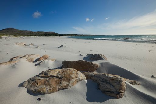 A beautiful view of the rocks on the sandy beach on the coast in Western Cape