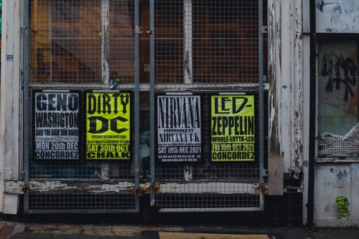 A closeup of band posters on dirty gates outdoors in Brighton and Hove, the UK