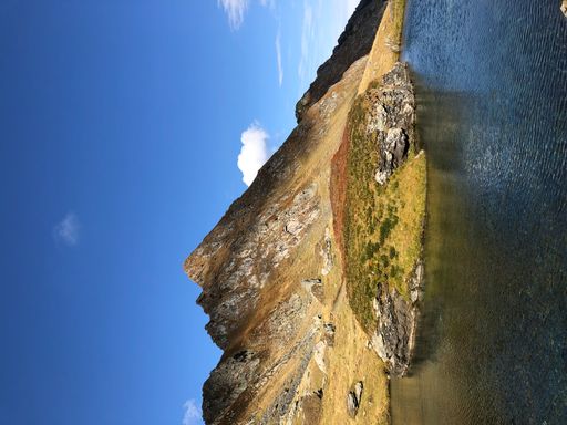 A vertical shot of a lake and mountains landscape in Romania