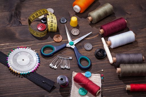 A closeup shot of colorful sewing tools on a wooden table surface
