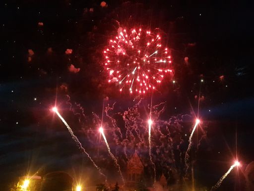 A low angle shot of colorful fireworks above a church at night - perfect for wallpapers