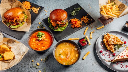 A top view of various food types soups, hamburgers, and dessert