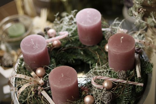 A top view of four candles on a wreath with Christmas decorations