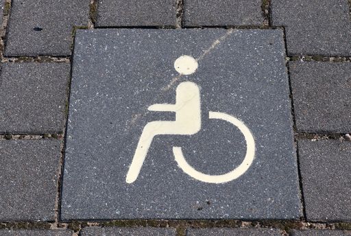 A high angle shot of a white disability sign painted on the ground