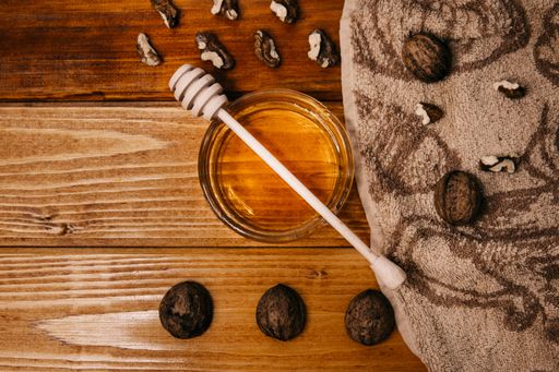 A top view of honey and walnuts on a wooden background
