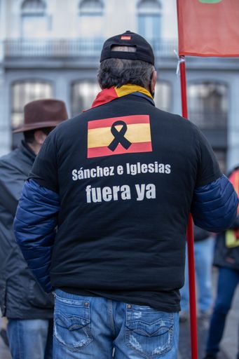 A vertical shot of a man wearing a shirt with the text ''Sanchez e Iglesias go out now''