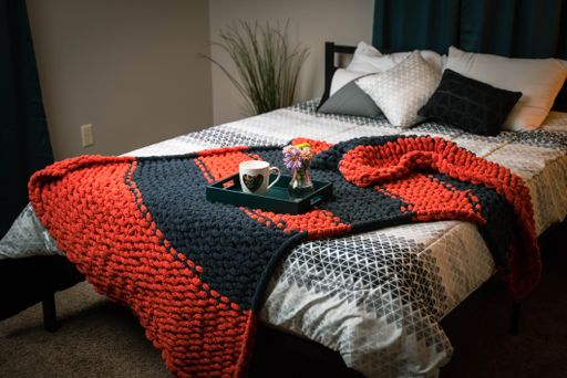 The home interior of cozy bedroom in modern design with pillows and soft custom made chunky blanket