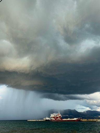 A vertical shot of huge gray clouds above the ocean in Neapoli, Greece