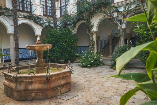 A beautiful view of a dry fountain on a tiled floor and trees in Roda de Bera, Catalonia, Spain