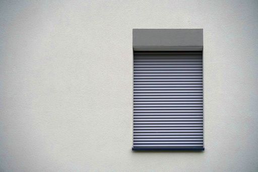 A window on a beige wall of a building during daytime