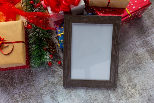 A blank wooden frame with Christmas gifts in the background