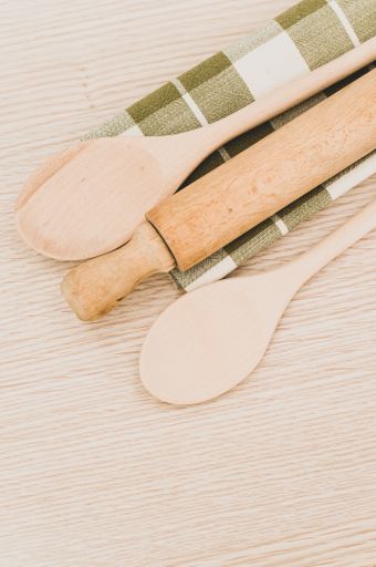 natural wood kitchen utensils and a table napkin on a wooden background with copy space