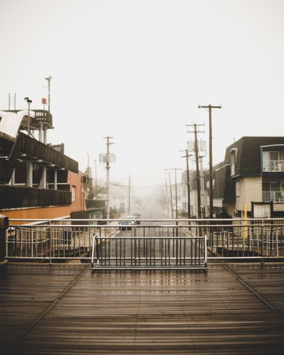 A vertical shot of a wooden pathway with metal stainless railings on it