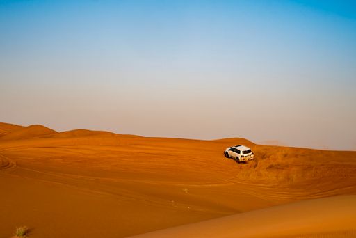 A beautiful shot of a car drifting in a desert during the day