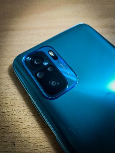A closeup shot of the back cameras in Xiaomi Redmi Note 10 in lake green color with blurred background