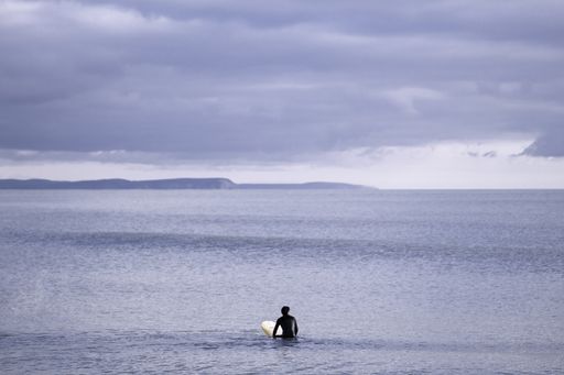 A beautiful view of an ocean under a cloudy gray sky