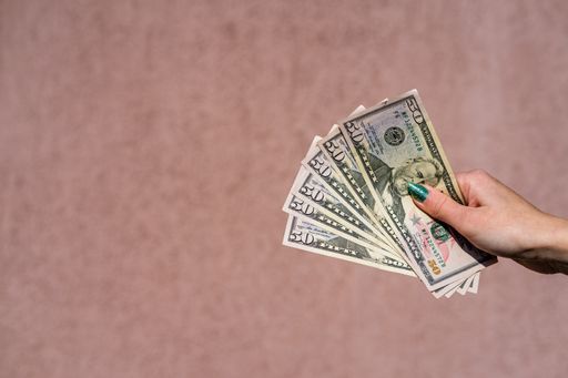A closeup shot of a female hand holding 50 dollar banknotes. Copyspace