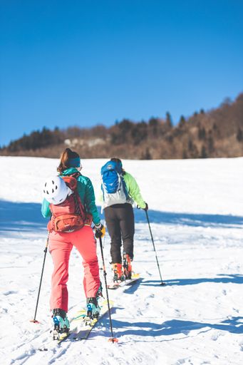 A vertical shot of two skiers going up a snowy hill in the Slovakian Mountains