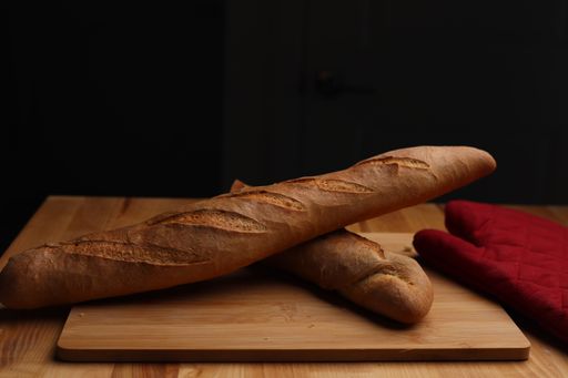 A closeup shot of loaves of baguettes on a cutting board