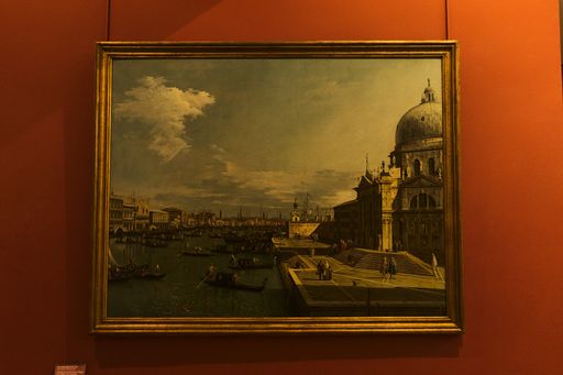 A painting hanging on the red wall of the Louvre museum, Paris, France